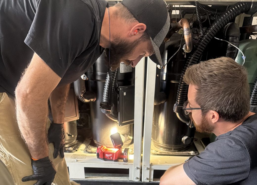 Two Mountain Hydronics Technicians working on a Chiller